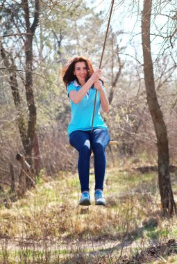 Güzel kız ormanda bungee üzerinde sallanan.