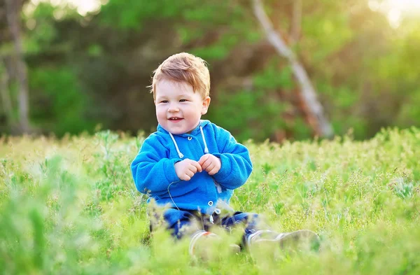美しい幸せな小さな赤ちゃん男の子緑の芝生の上に座って、playin — ストック写真