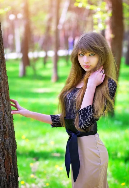 Güzel genç kız rahatlatıcı bahar yeşil bir ormanda — Stok fotoğraf