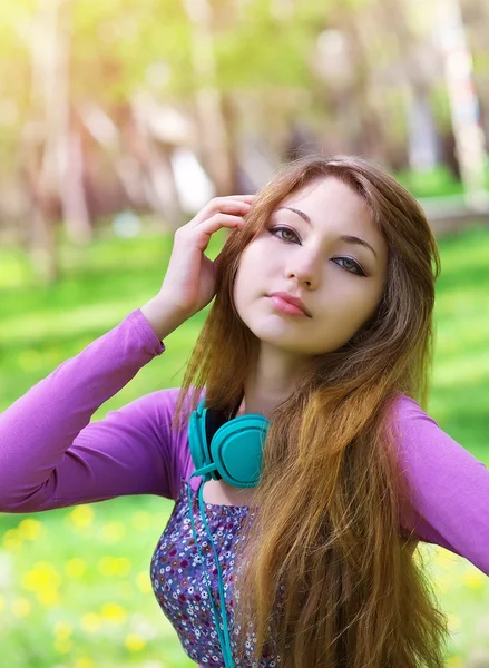 Hermosa joven con auriculares en el parque —  Fotos de Stock