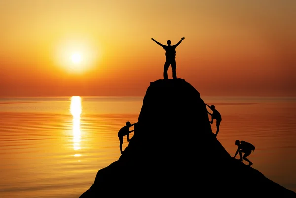 Silueta de un hombre en la cima de una montaña sobre el fondo del atardecer. Spo. — Foto de Stock