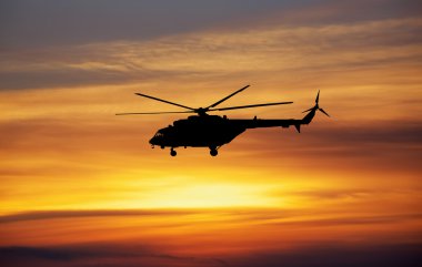 Resim gün batımında helikopter. Günbatımı gökyüzü helikopterde silüeti.