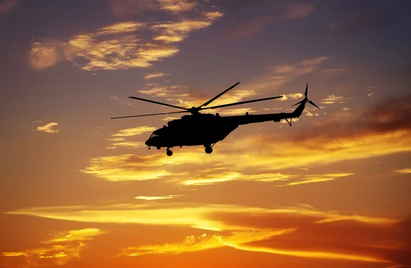 Picture of helicopter at sunset. Silhouette of helicopter on sun — Stock Photo, Image