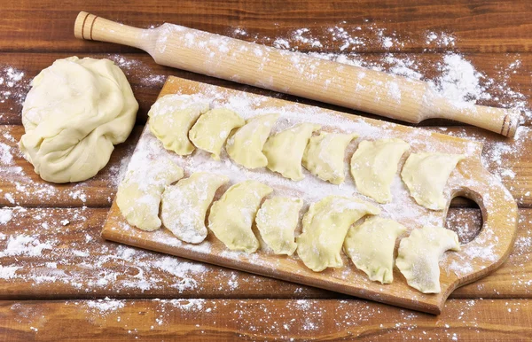 Varik met aardappelen op een snijplank vóór het koken. — Stockfoto