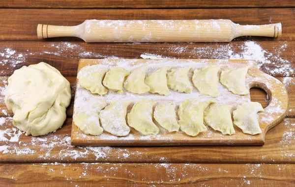 Vareniki con patate su un tagliere prima di cottura . Immagine Stock