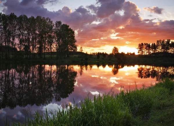 Beautiful landscape with fiery sunset over the lake — Stock Photo, Image