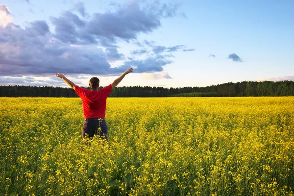 Farmer with outstretched arm at the rape field. — Stock Photo, Image