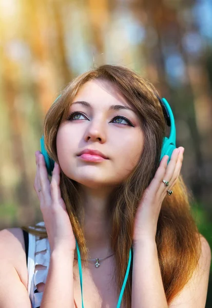 Hermosa chica joven con auriculares — Foto de Stock
