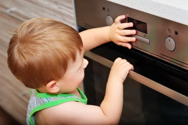 Bambino che gioca con il forno elettrico Immagine Stock