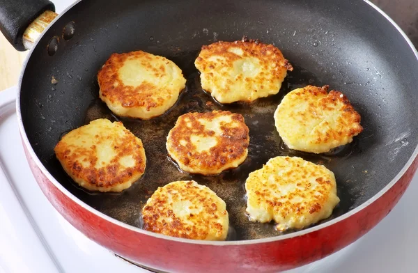 Beautiful golden cheese pancakes fried in a pan. Syrniki.