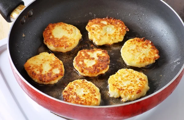 Hermosos panqueques de queso dorado fritos en una sartén. Syrniki. . —  Fotos de Stock