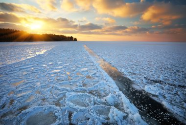 Günbatımı gökyüzü ve donmuş gölün güzel kış manzarası
