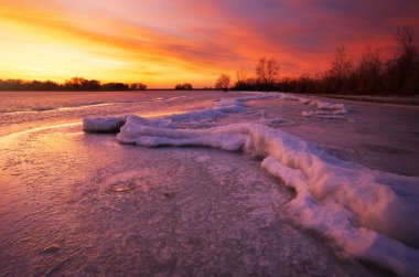 Günbatımı ateşli gökyüzü ile kış manzarası.