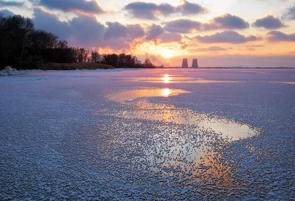 Beautiful winter landscape with sunset sky frozen reservoir and power plant — Stock Photo, Image