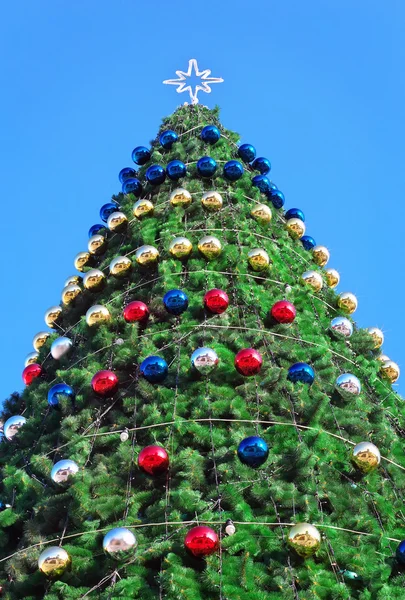 Украшенная елка. Рождественская елка против голубого неба — стоковое фото