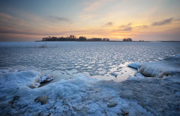 Vackert vinterlandskap med frusen sjö och solnedgång himmel. — Stockfoto