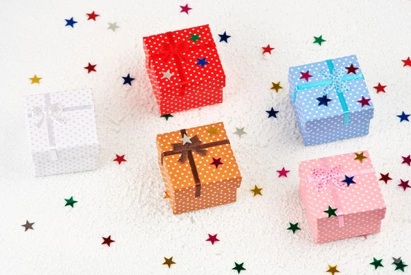Цветные рождественские подарки остряки звезд в снегу — стоковое фото