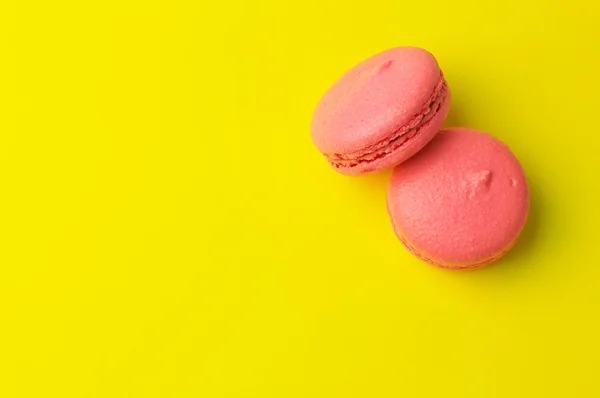 Pink macaroons on yellow background — Stock Photo, Image