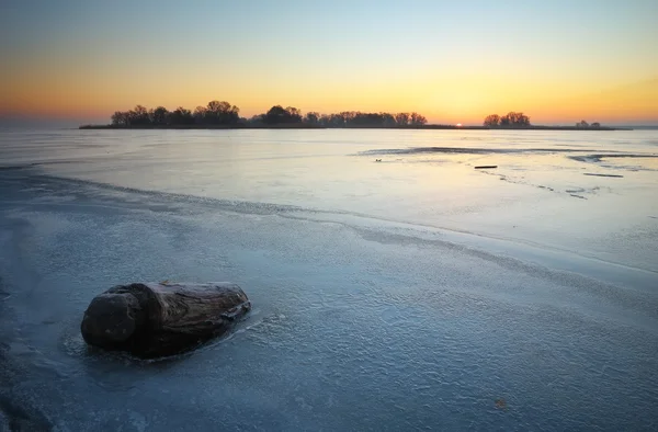 Hermoso paisaje de invierno con tocón en el hielo y la puesta de sol —  Fotos de Stock