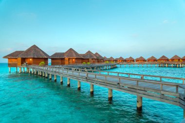 Maldivler cenneti manzarası. Su bungalovlu deniz burnu, güzel turkuaz deniz ve lagün suları, tropikal doğa. Egzotik tropikal ada plajı.