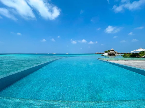 马尔代夫海滩广阔的全景和无限大的游泳池 码头附近的地平线上有游艇 海景与水平房 美丽的绿松石海和泻湖水 热带自然天堂 — 图库照片