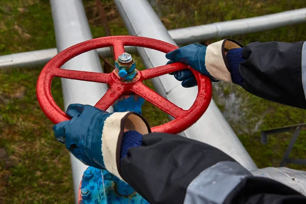 Técnico, manos en guantes de goma al abrir o cerrar una válvula de bola manual para el proceso de control en una plataforma de petróleo y gas en alta mar — Foto de Stock