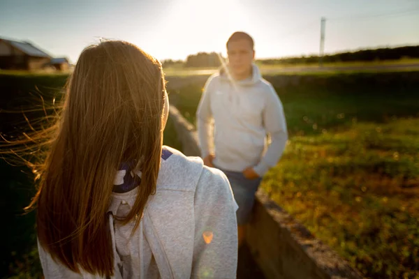 História de amor de uma mulher e um homem. Um casal amoroso olha um para o outro. contra o sol poente — Fotografia de Stock