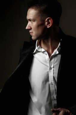 Siyah arka planda şık bir erkek portresi. Stüdyo portresi. Klasik takım elbiseli bir manken.