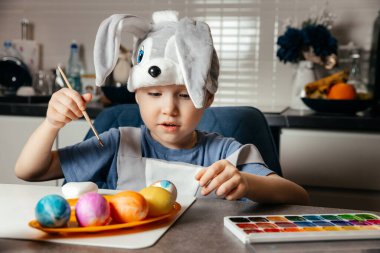 Mutfakta paskalya yumurtası çizen beş yaşındaki sevimli bir tavşancığın yakın çekimi. Şenlik Konseri