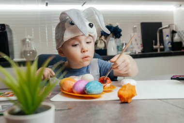 Mutfakta paskalya yumurtası çizen beş yaşındaki sevimli bir tavşancığın yakın çekimi. Şenlik Konseri