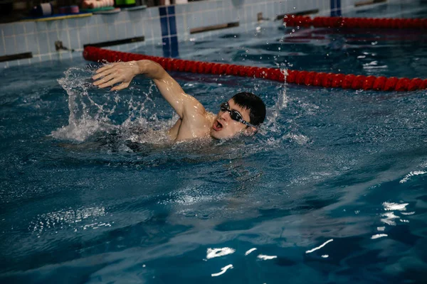 Male swimmer, free style swimming on the swimming track in the indoor pool — Stock Photo, Image