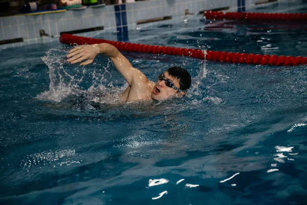 Male swimmer, free style swimming on the swimming track in the indoor pool — Stock Photo, Image