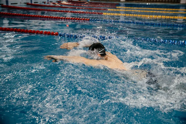 Strong athletic muscular Caucasian male swims butterfly. Concept of preparing athletes for competitions — Stock Photo, Image