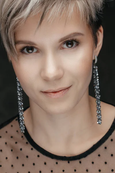 Beautiful portrait of a white woman with a short stylish haircut on a black background. Beautiful blue eyes, natural beauty of clean skin, facial and hair care. — Stock Photo, Image