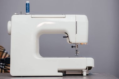 Dikiş atölyesindeki bir masada dikiş makinesi.