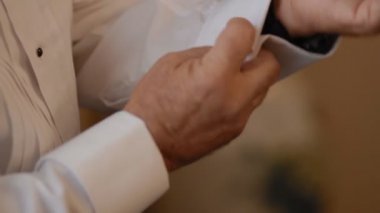 Damat düğme kelepçeleri onun beyaz gömlek