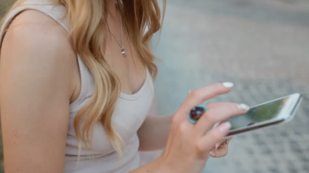 Mujer rubia joven usar su teléfono al aire libre — Vídeos de Stock