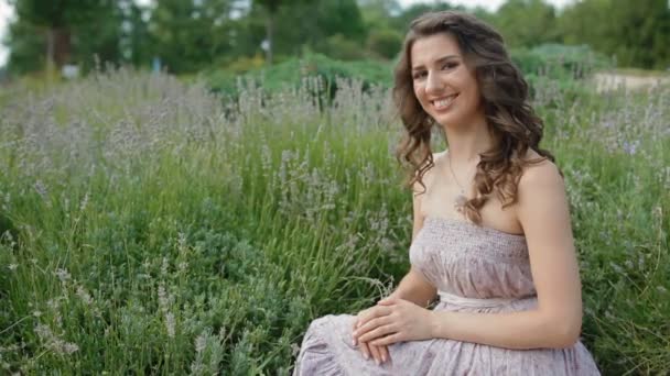 Young woman sit in lavender and smile. — Stock Video