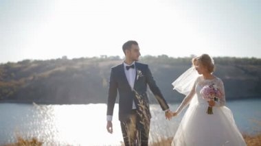 Gelin ve damat nehir kenarında yürüyüş