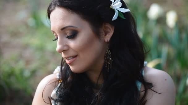 Young woman pose with flowers on background — Stock Video