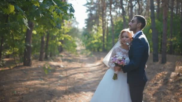 Nevěsta a ženich pózuje v lese — Stock video