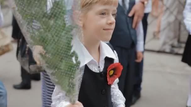 Dnepr, ukraine - 1. September 2015: ukrainische Kinder beginnen die Schule. Porträt eines ersten ehemaligen Mädchens mit einem Blumenstrauß. — Stockvideo