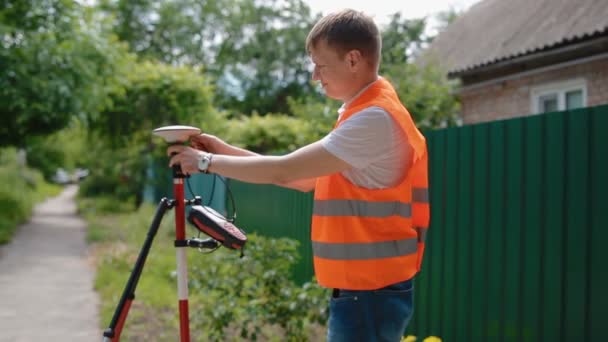 Trabajador prepara dispositivo geodésico para la topografía — Vídeo de stock