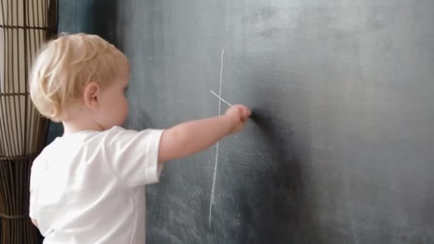 Pequeño niño dibujar una tiza sobre pizarra — Vídeos de Stock