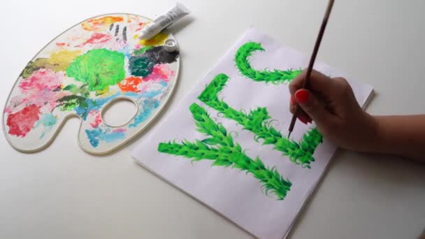 Frau malt grüne Blätter auf das Wort "Ja" — Stockvideo