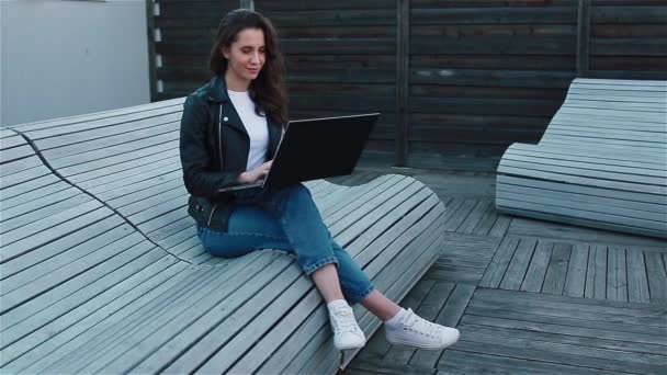 Young woman with laptop outside — Stock Video