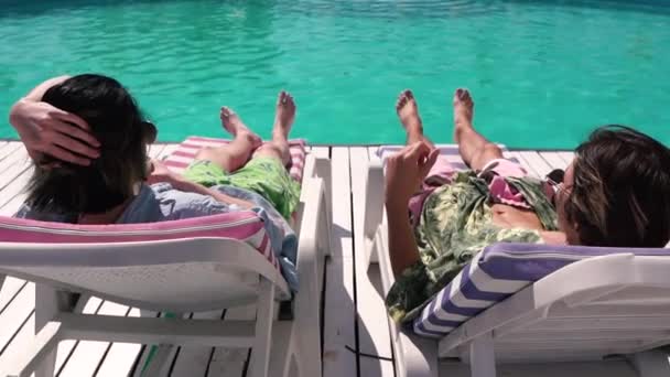 Young men chilling on the sun lounger — Stock Video