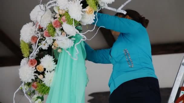 Woman decorate wedding arch with the green fabric — Stock Video