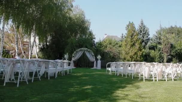 Wedding decoration with arch and white chairs — Stock Video