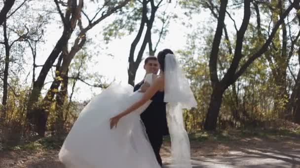 Groom whirl his bride keeping her on arms.Wedding photo session. — Stock Video